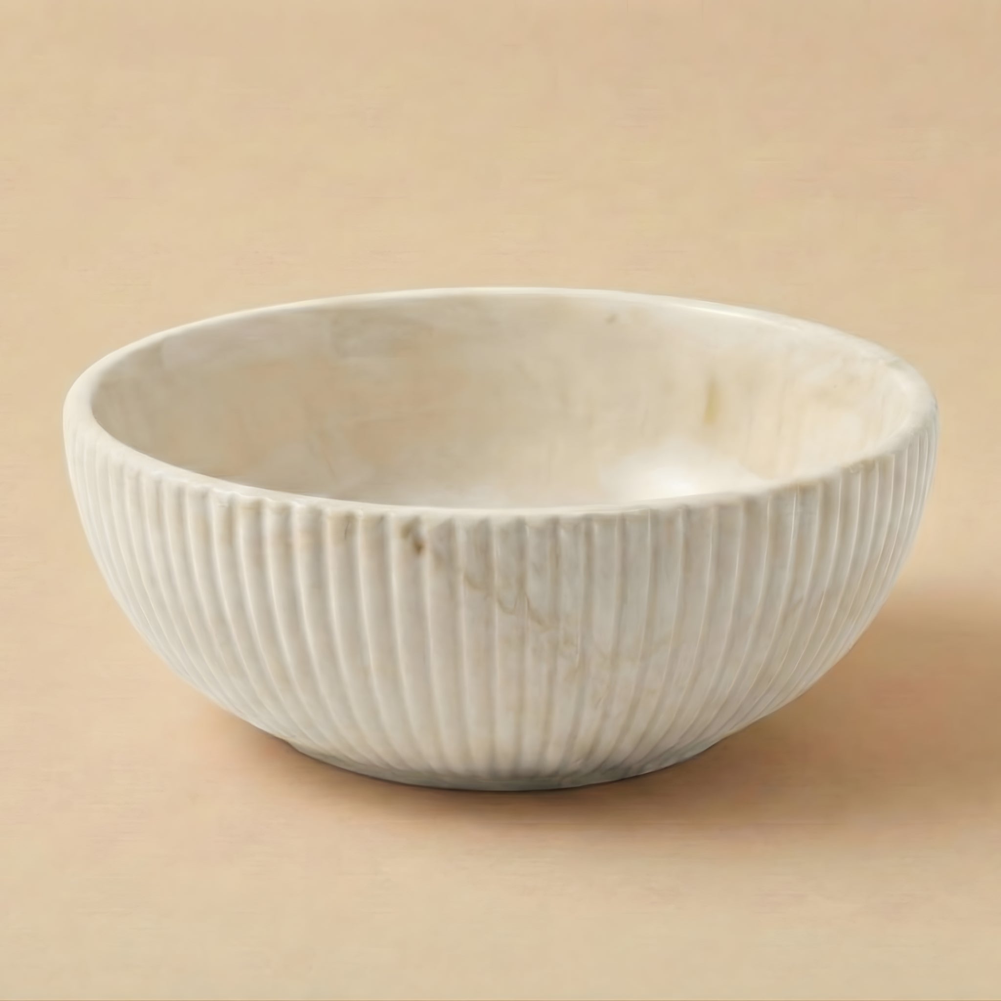 White ceramic bowl with ribbed texture on a beige background